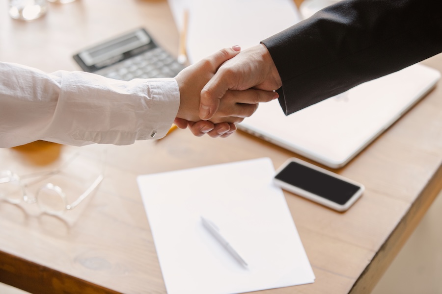 Dos personas se dan la mano tras cerrar un acuerdo de mediación
